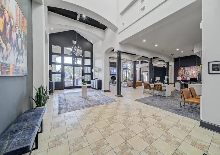 Elegant and spacious apartment lobby featuring high ceilings, modern decor, and chic seating areas with a welcoming ambiance.