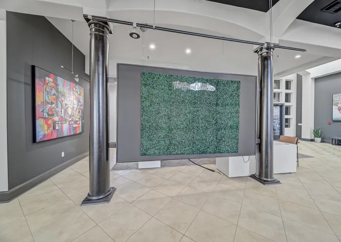Elegant lobby at The Grand Venetian featuring a lush green wall and vibrant abstract artwork, showcasing a sophisticated ambiance with modern design elements.