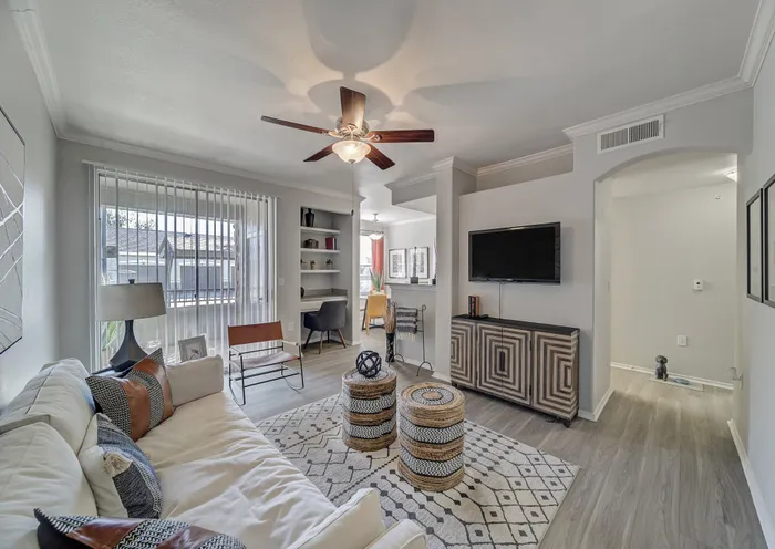 Modern living room featuring cozy seating, chic decor, and a large window with plenty of natural light.
