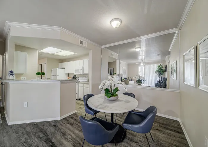 Modern apartment interior with elegant dining area, stylish kitchen, and bright living room, featuring sleek finishes and contemporary decor.