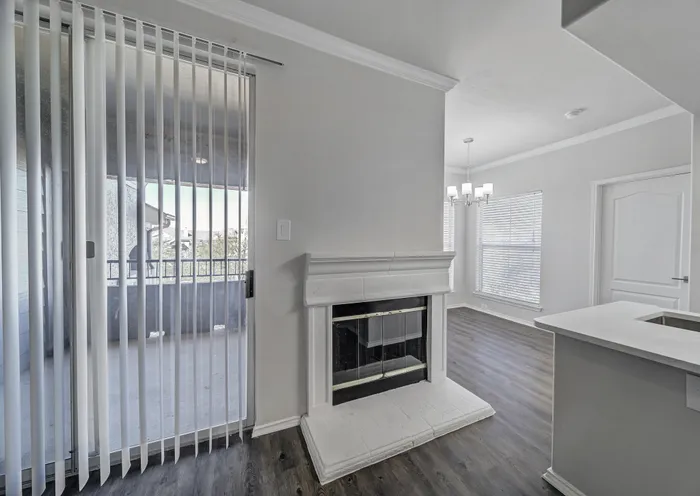 Bright apartment featuring a modern fireplace, elegant chandelier, and large patio doors for ample natural light.