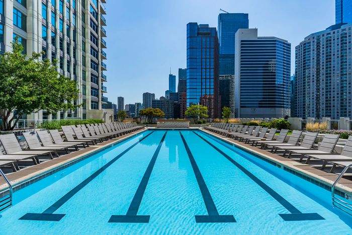 Luxurious rooftop pool with plush sun loungers and stunning city skyline views.