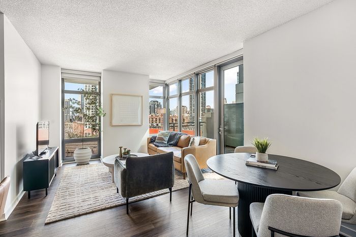 Bright, modern open-plan living space with stylish decor and city views through expansive windows.