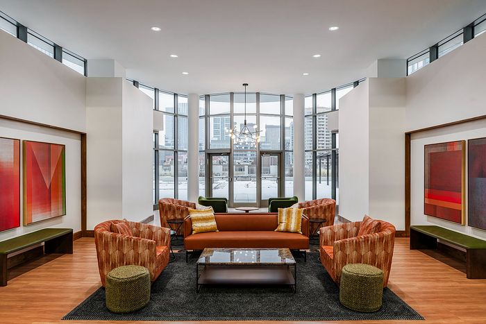 Inviting urban lounge with panoramic windows, chic seating, and modern art in a vibrant high-rise building.