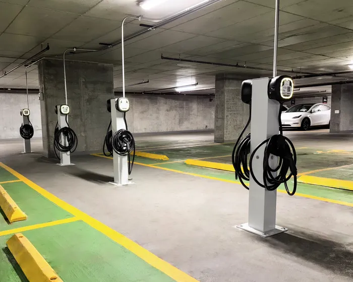 Modern parking garage featuring multiple electric vehicle charging stations with sleek design and ample space.