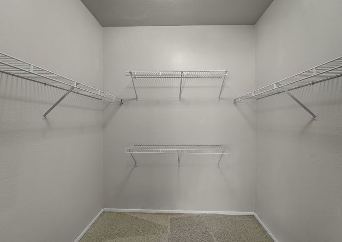 Spacious walk-in closet with multiple wire shelves, perfect for organized storage solutions.