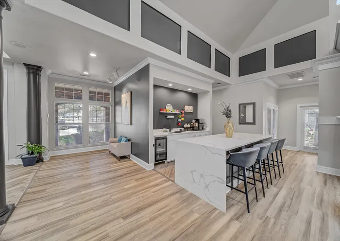 Bright modern living space with high ceilings, natural wood flooring, stylish kitchen island, and elegant seating area.
