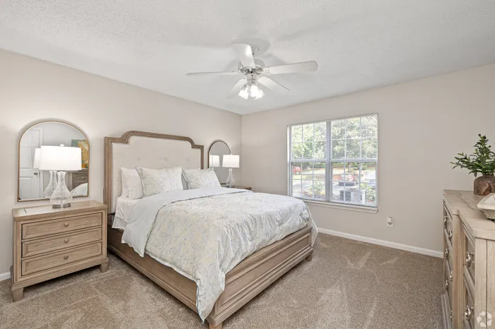 Bright, airy bedroom with elegant decor, featuring a plush bed, stylish wooden nightstands, and large windows flooding the room with natural light.