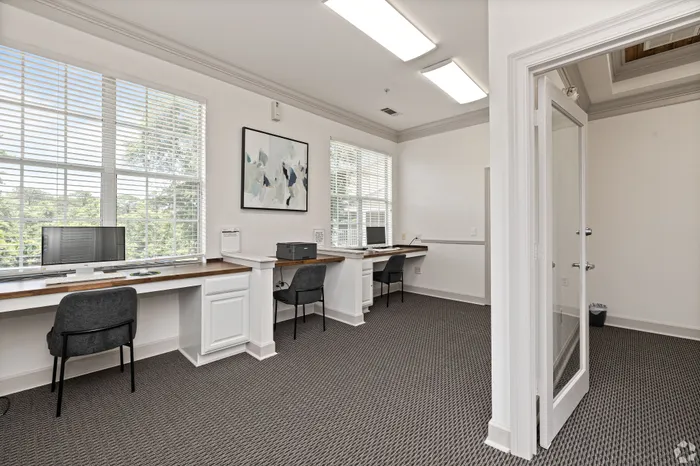 Bright and modern home office space with large windows, sleek desks, and comfortable seating, perfect for productivity.