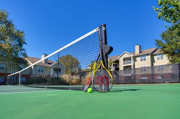 Bright apartment community with a well-maintained tennis court, perfect for outdoor recreation and active living.