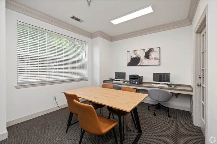 Bright and modern home office space with elegant desk, comfortable chairs, large window, and stylish decor.