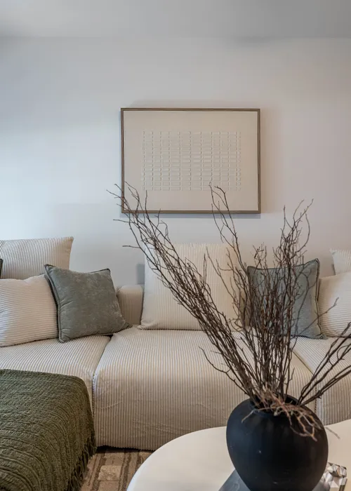 Chic and inviting living room with a cozy sofa, elegant decor, and modern artwork creating a serene ambiance.