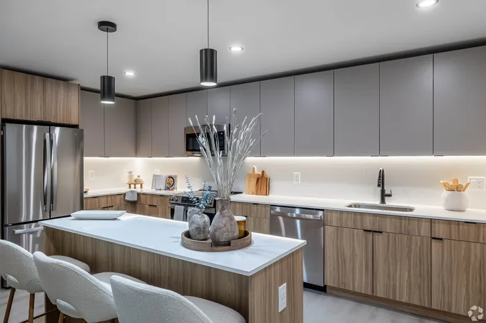 Sleek modern kitchen with wood cabinets, stainless steel appliances, and a chic island with stylish bar stools.
