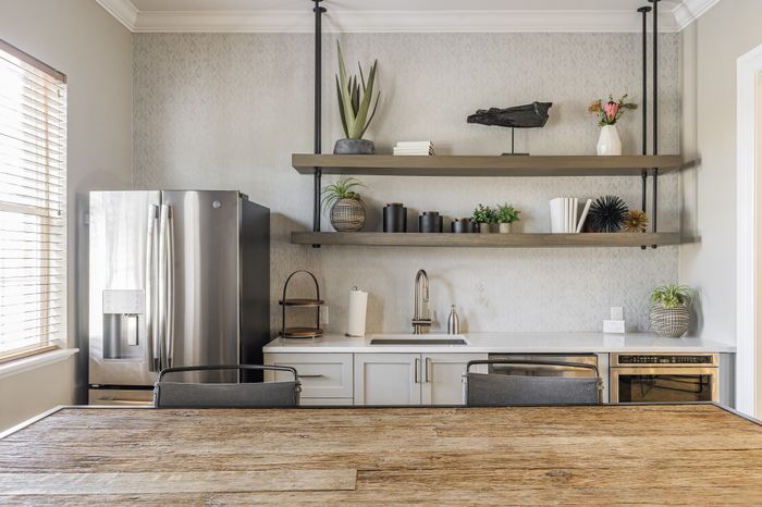 Modern kitchen with sleek stainless steel appliances, elegant open shelving, and chic decor elements for an inviting atmosphere.