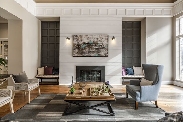 Elegant living room featuring a cozy fireplace, stylish armchairs, and a chic coffee table with artistic decor accents.