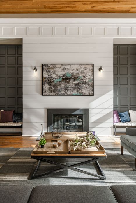 Chic living room featuring a stylish fireplace, modern artwork, and cozy seating, accented with contemporary decor and warm wood ceilings.