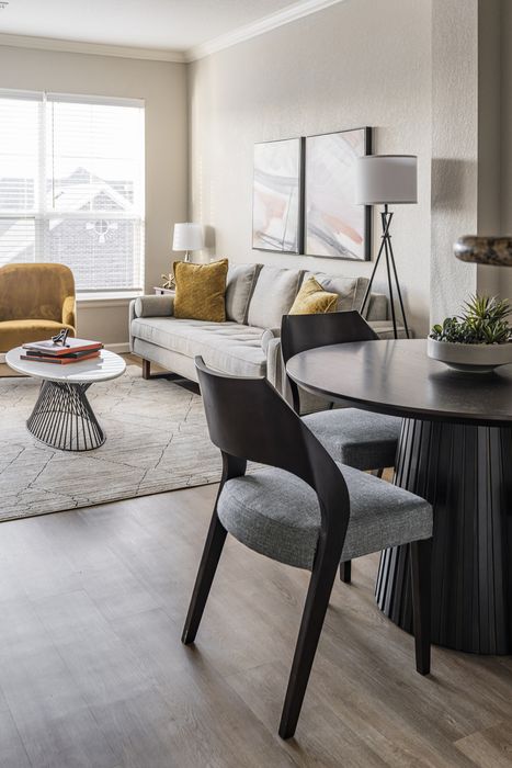 Welcoming living room with cozy gray sofa, elegant furnishings, and natural light from large windows.