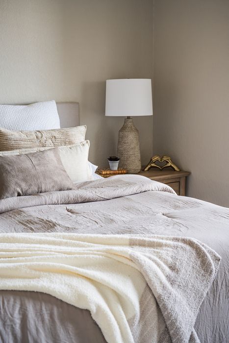 Inviting bedroom setting with cozy neutral tones, plush bedding, and elegant decor, perfect for relaxation.
