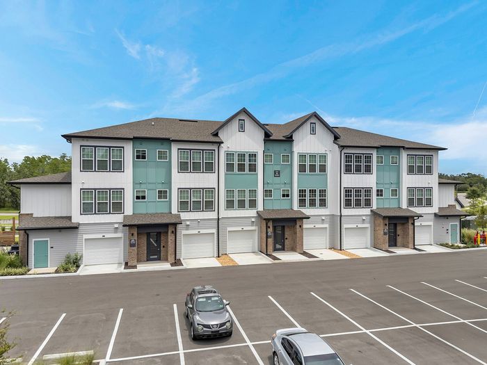 Contemporary multi-story apartment building with modern facade and dedicated parking in a serene setting.