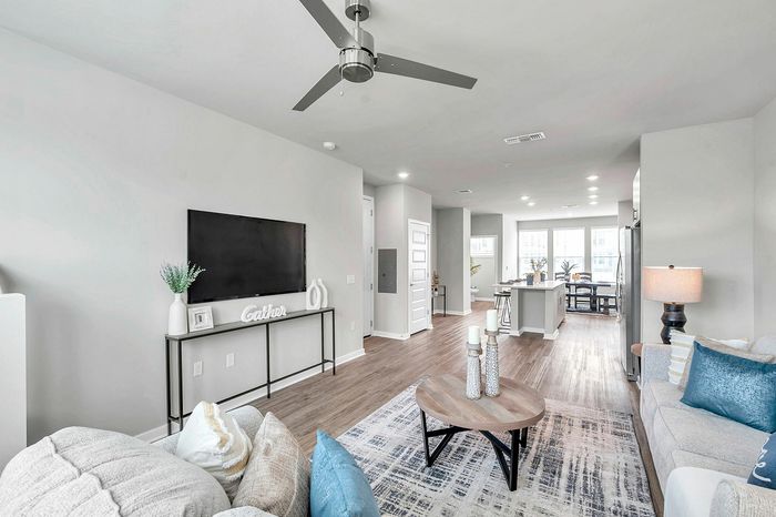 Bright and modern open-concept living area with elegant decor, featuring a cozy sitting space and contemporary kitchen.
