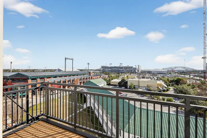 Inviting balcony view overlooking a vibrant sports complex, perfect for sports enthusiasts and city life lovers.