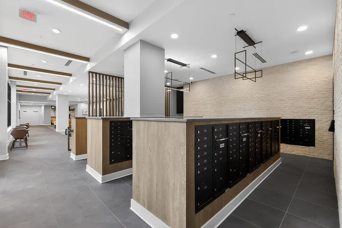 Modern apartment mailroom with sleek design, featuring spacious layout, stylish wood accents, and ample locker storage.