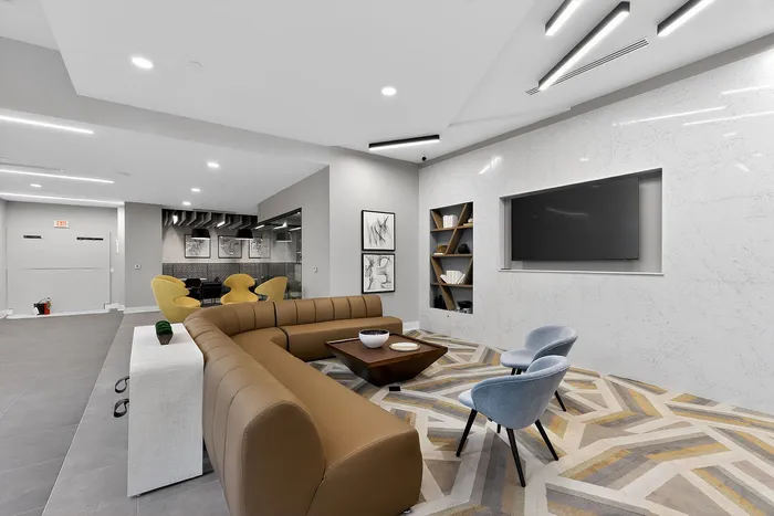 Sleek and modern lounge area with plush seating, geometric rug, and elegant wall d&eacute;cor, perfect for relaxation and socializing.