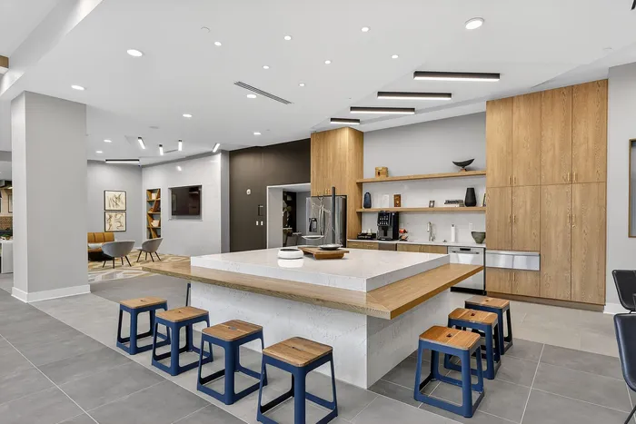 Modern kitchen space with a large center island, sleek cabinetry, and contemporary bar stools in an open-concept design.