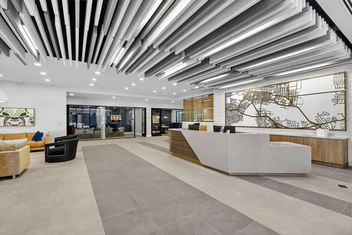 Modern lobby with sleek reception desk, stylish seating area, and unique ceiling design, creating a welcoming first impression.