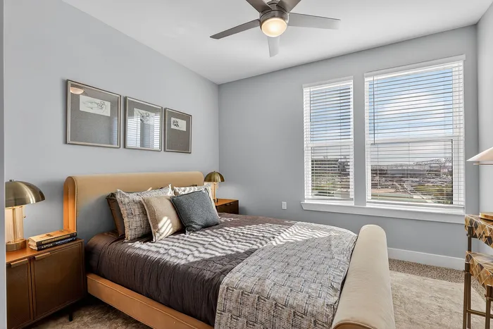 Bright bedroom with a plush bed, elegant decor, and large windows offering scenic views.