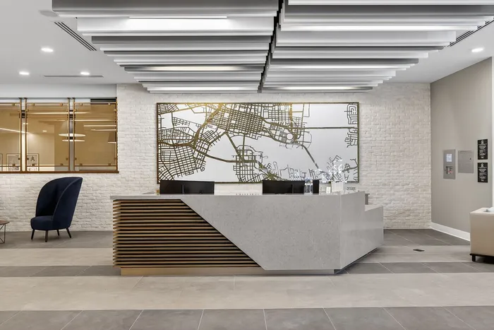 Modern apartment lobby with sleek reception desk, elegant map art, and stylish seating.