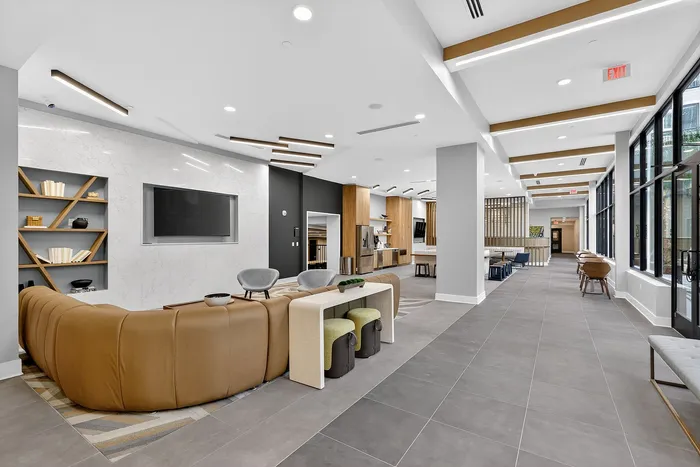 Contemporary apartment lounge boasting elegant seating, modern decor, and expansive windows for abundant natural light.