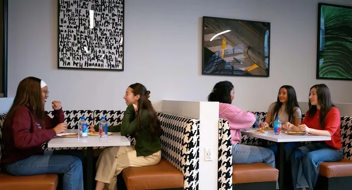 Chic dining area with stylish artwork, featuring cozy booths and a lively atmosphere, perfect for social gatherings.