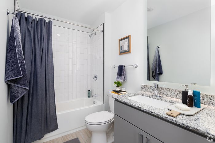 Elegant bathroom featuring a granite countertop, modern fixtures, and a stylish shower curtain for a luxurious touch.
