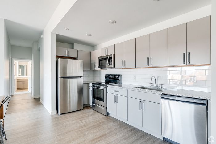 Modern kitchen with sleek stainless steel appliances, elegant white cabinetry, and ample natural light for a bright, airy atmosphere.