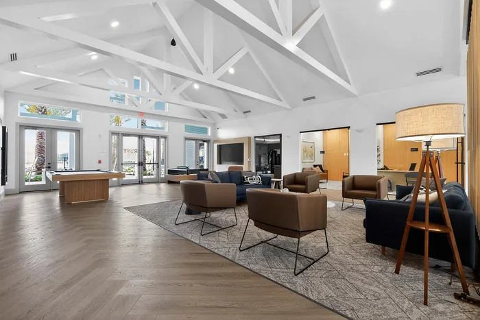 Chic and spacious lobby with vaulted ceilings, modern seating, and abundant natural light, perfect for relaxation or casual meetings.