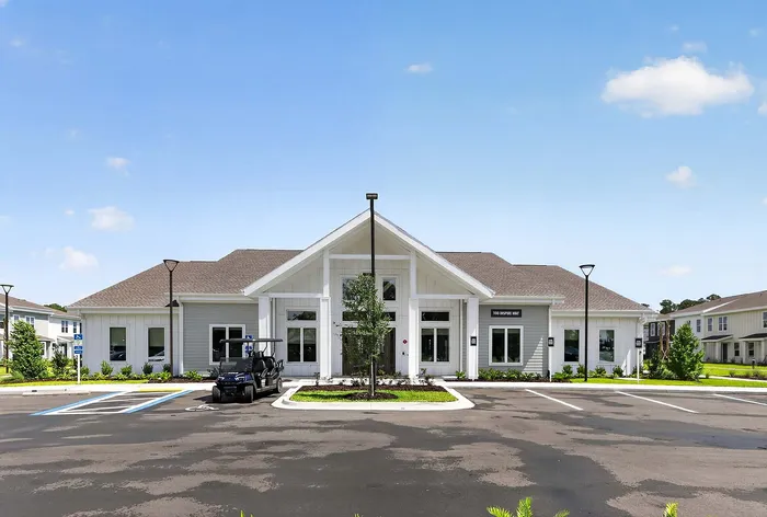 Elegant and spacious residential building with contemporary design, featuring a welcoming entrance and well-maintained surroundings under a clear blue sky.