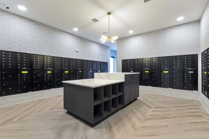 Modern mailroom with sleek black mailboxes, elegant lighting, and a stylish central island, ideal for convenient parcel sorting.