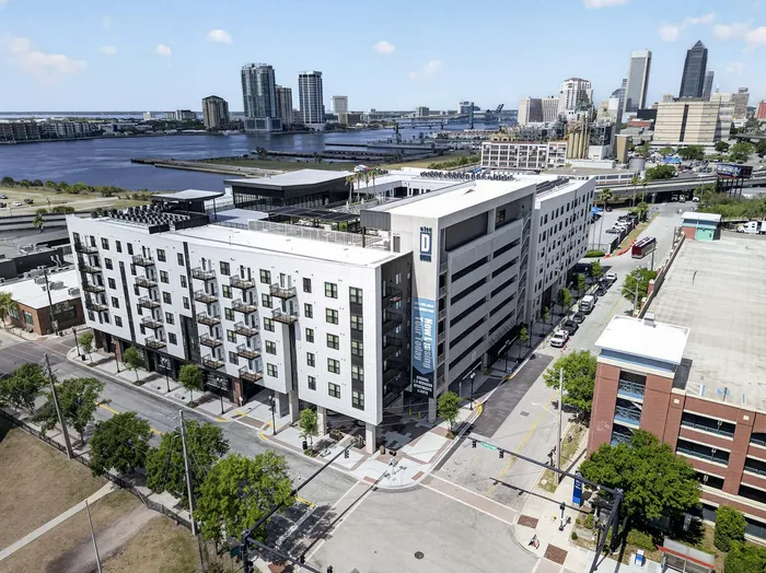 Modern apartment complex with balconies in a vibrant urban area, offering river views and close proximity to downtown attractions.