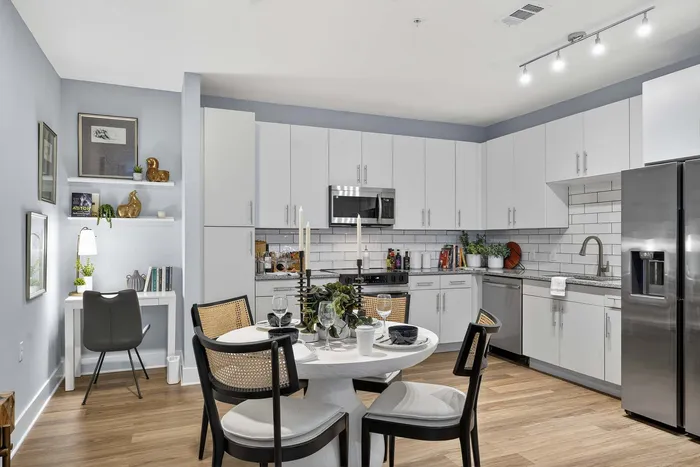 Modern kitchen with sleek white cabinetry, stainless steel appliances, and an elegant dining area, perfect for entertaining.