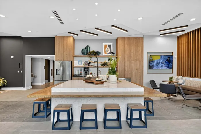 Contemporary open-concept kitchen with sleek design, featuring a large island with seating, stainless steel appliances, and modern lighting.