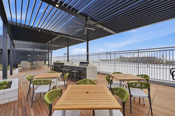 Modern rooftop terrace with a stylish pergola, comfortable seating, and stunning city views, perfect for relaxation and outdoor dining.