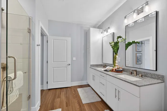 Elegant bathroom featuring a spacious double vanity with sleek countertops, stylish mirrors, and modern fixtures.