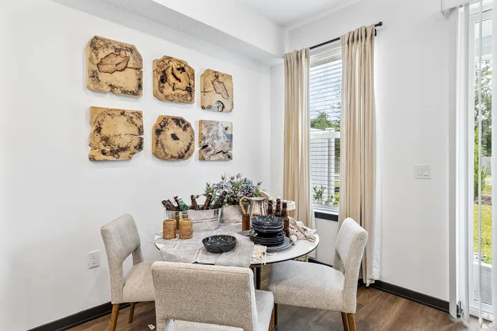 Charming dining nook with modern decor, featuring a round table set for entertaining and unique wall art accentuating the cozy ambiance.
