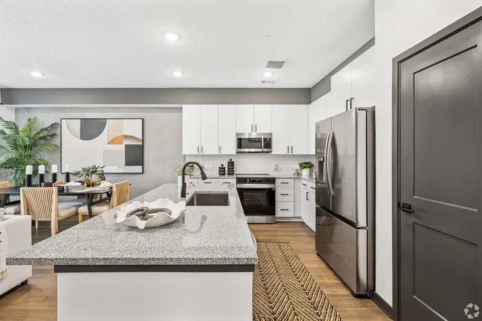 Modern kitchen with sleek granite countertops, stainless steel appliances, and stylish dining area creating an inviting atmosphere.