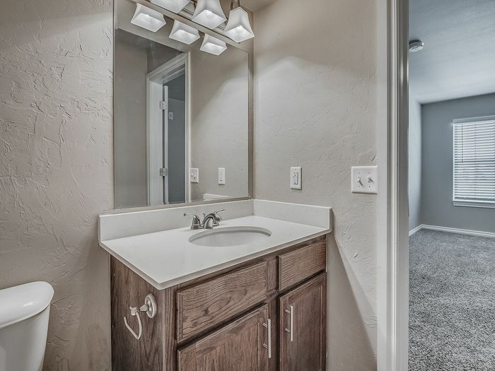 Elegant bathroom with modern vanity and bright adjacent bedroom.