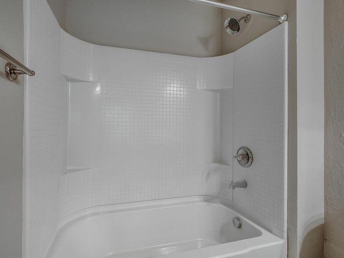 Elegant bathroom with a modern white bathtub and tiled walls.