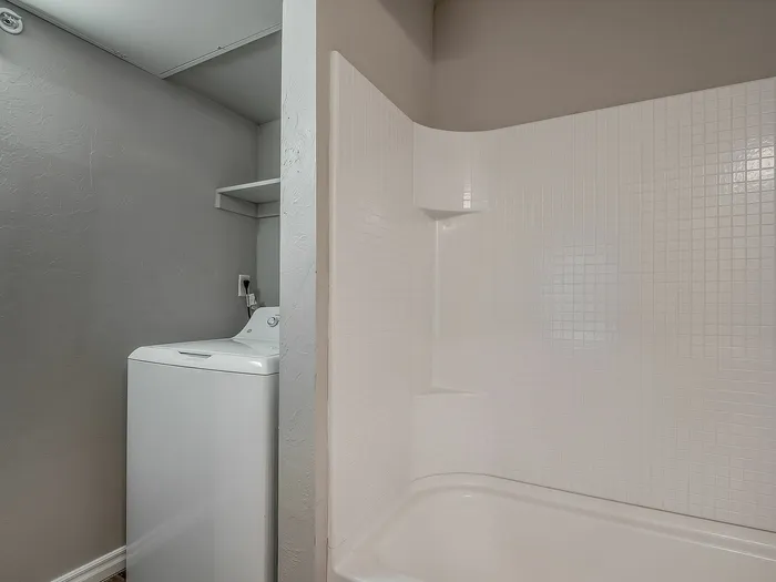 Bright bathroom with a bathtub and a conveniently placed washing machine.