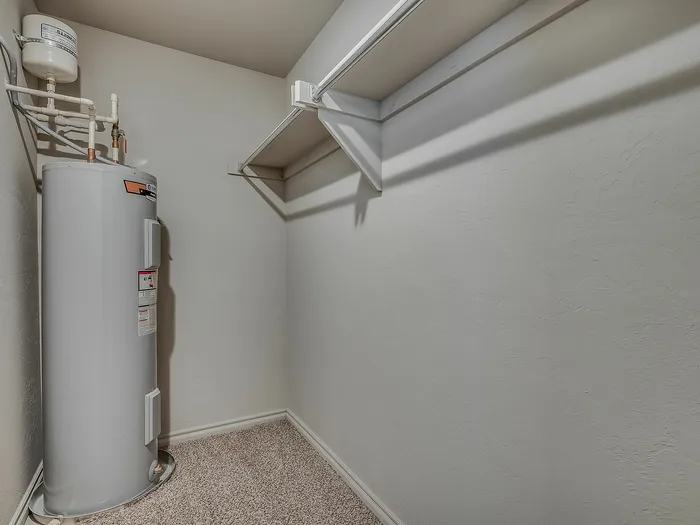 Efficient storage space featuring a water heater and ample shelving.