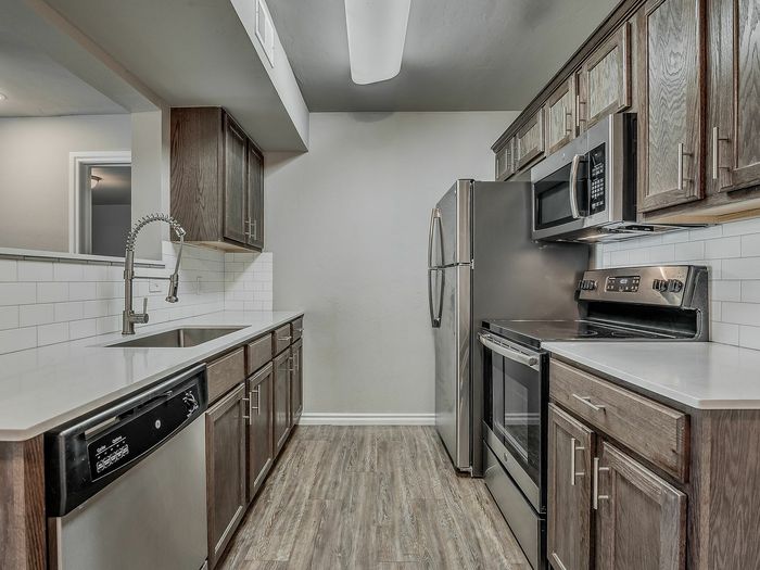 Modern kitchen with sleek stainless steel appliances, elegant wood cabinetry, and pristine countertops.